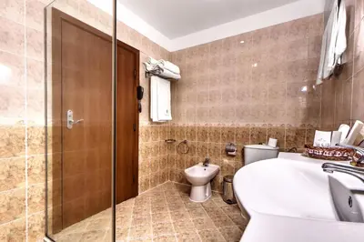 a bathroom with a sink and a toilet at Спа Хотел Орфей in Devin
