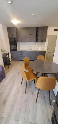 a kitchen and dining room with a table and chairs at Predela 2 Aparthotel Ski & Spa 200m from slopes in Bansko