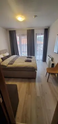 a large bedroom with a bed and a desk and windows at Predela 2 Aparthotel Ski & Spa 200m from slopes in Bansko