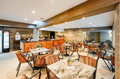 a restaurant with tables and chairs and a kitchen at Predela 2 Aparthotel Ski & Spa 200m from slopes in Bansko