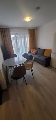 a living room with a table and a couch at Predela 2 Aparthotel Ski & Spa 200m from slopes in Bansko