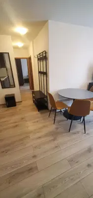 a dining room with a table and chairs on a wooden floor at Predela 2 Aparthotel Ski & Spa 200m from slopes in Bansko