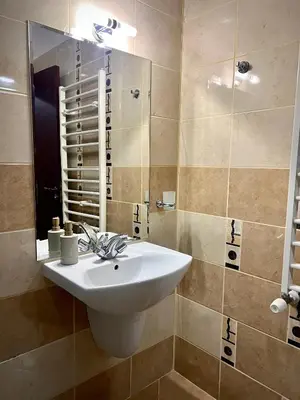 a bathroom with a white sink and a mirror at Elite Apartments Flora Residence in Borovets