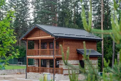 a log cabin with a black roof at Борово ухание Говедарци Pine scent Govedartsi in Govedartsi