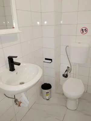 a white bathroom with a toilet and a sink at GuestHouse3 Karma369 in Plovdiv