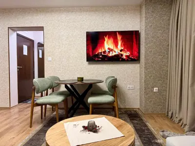 a living room with a fireplace and a table and chairs at Deluxe Apartment 34 Mountain Lodge Pamporovo in Pamporovo