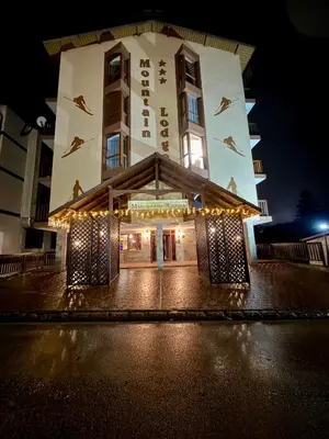 a building with lights in front of it at night at Deluxe Apartment 34 Mountain Lodge Pamporovo in Pamporovo