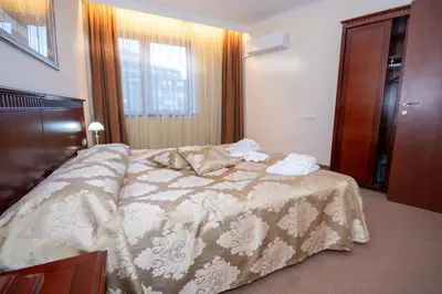 a bedroom with a bed with a brown and white comforter at Ametist - Comfort by the Gondola Lift in Bansko