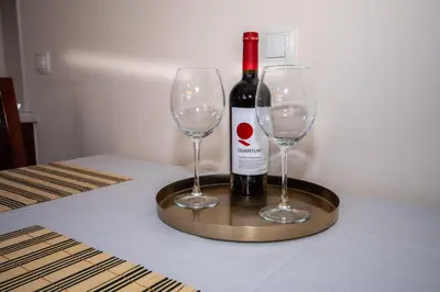 a bottle of wine and two wine glasses on a table at Ametist - Comfort by the Gondola Lift in Bansko