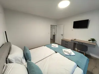 a bedroom with a bed and a desk and a television at Карина - къща за гости in Ognyanovo