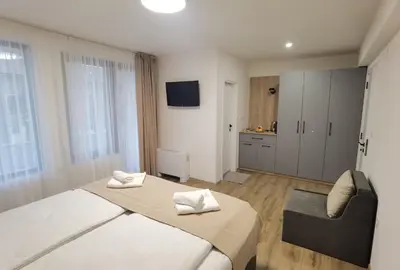 a bedroom with a bed and a chair in it at Карина - къща за гости in Ognyanovo