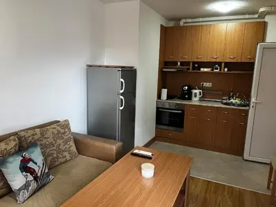 a living room with a couch and a table in a kitchen at Lucky Star Bansko Next to the Ski Lift with FREE Parking in Bansko