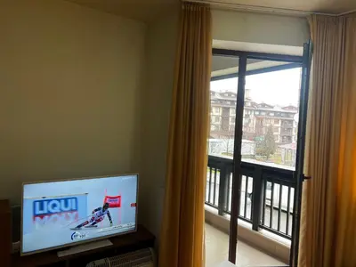 a living room with a television and a window at Lucky Star Bansko Next to the Ski Lift with FREE Parking in Bansko