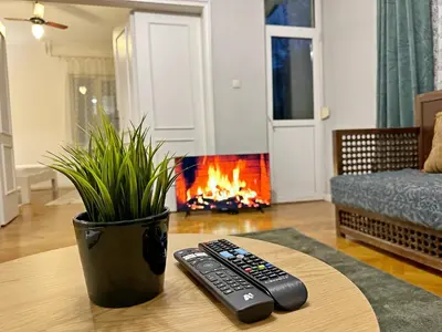 two remote controls sitting on a table in front of a fireplace at Elegant 2BDR Apt for groups and family - Fast Wi-Fi in Sofia