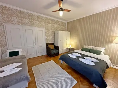a bedroom with a bed and a couch and a fan at Elegant 2BDR Apt for groups and family - Fast Wi-Fi in Sofia