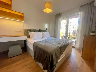 a bedroom with a bed with a desk and a window at Casa Brisa by Vistay Residences Apartment Sofia - with Free Secured Parking in Sofia