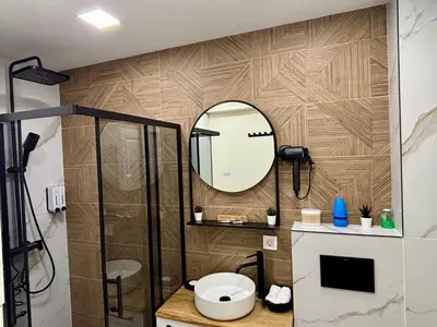 a bathroom with a shower and a toilet and a mirror at Casa Brisa by Vistay Residences Apartment Sofia - with Free Secured Parking in Sofia