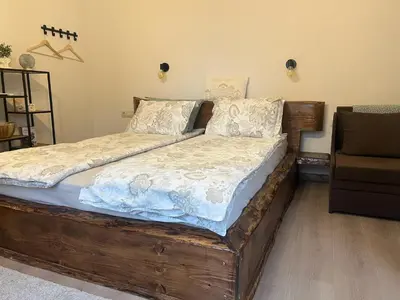 a bed with a wooden frame in a room at Rilski Chardak in Sapareva Banya