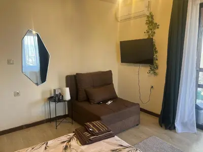 a living room with a couch and a flat screen tv at Rilski Chardak in Sapareva Banya