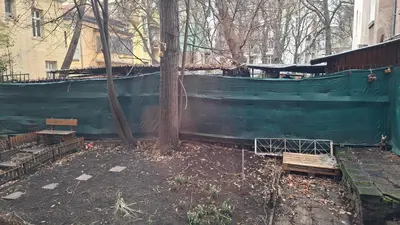 a green fence with benches next to a building at NG- apartments in Sofia