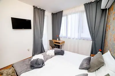 a bedroom with a bed with a desk and a window at Pirin SkiLift Apartment - Cozy & Modern App in Bansko, 100 m to the Gondola in Bansko