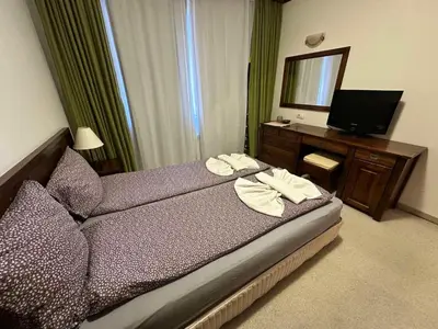 a bedroom with a bed and a television and a mirror at St Ivan Rilski spacious apartment in Bansko