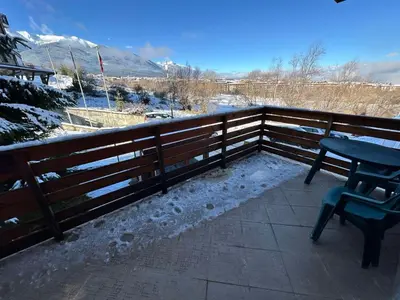 a patio with a bench and a fence with snow at St Ivan Rilski spacious apartment in Bansko