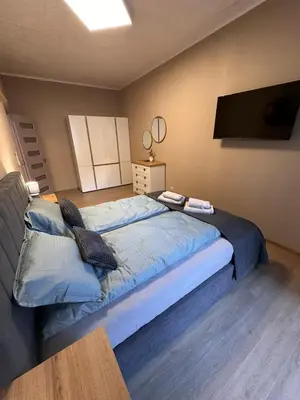 a bedroom with a large bed and a flat screen tv at Apart-Hotel Crow Bansko 3 in Bansko