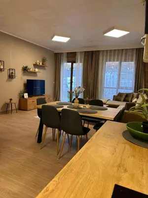 a living room with a couch and a table and chairs at Apart-Hotel Crow Bansko 3 in Bansko