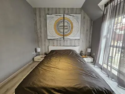 a large bed in a room with a large window at Bulgaria Mall Flat in Sofia