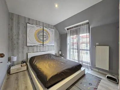 a bedroom with a bed and a large window at Bulgaria Mall Flat in Sofia