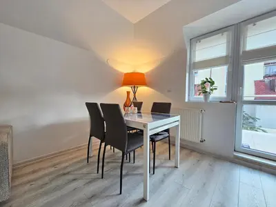 a dining room with a table with chairs and a lamp at Bulgaria Mall Flat in Sofia