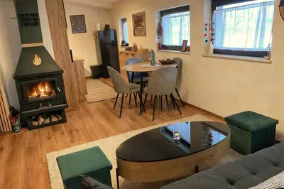 a living room with a table and a fireplace at Студио за гости Петрови in Bansko