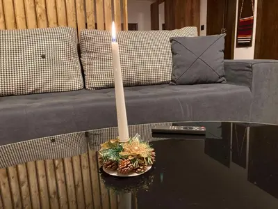 a candle on a table in front of a couch at Студио за гости Петрови in Bansko