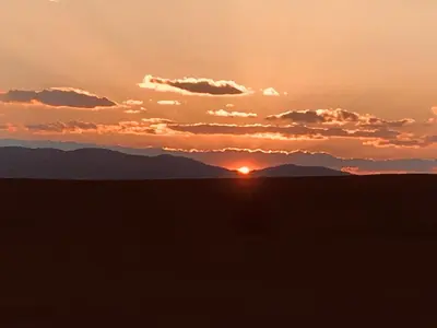 a sunset in the desert with mountains in the background at Relyovo Lodge in Relyovo