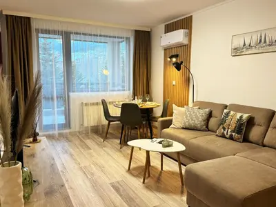 a living room with a couch and a table at Alpine Glow - Panoramic View near Gondola in Bansko