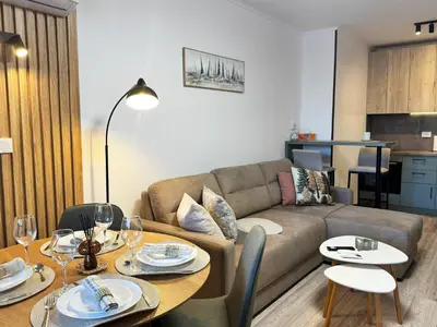 a living room with a couch and a table at Alpine Glow - Panoramic View near Gondola in Bansko