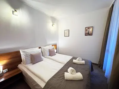 a hotel room with a bed with towels on it at Alpine Glow - Panoramic View near Gondola in Bansko