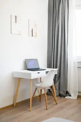a white desk with a laptop on it next to a chair at 2-Bedroom Apartment near Tokuda Hospital & Paradise Mall in Sofia