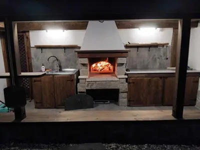 a kitchen with an oven with a fire in it at Пътепис in Bratsigovo