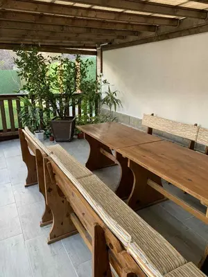 two wooden benches in a room with plants at Пътепис in Bratsigovo