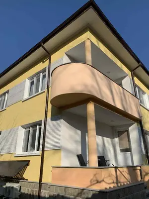 a yellow and white building with a large window at Пътепис in Bratsigovo