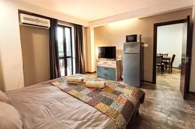 a hotel room with a bed and a refrigerator at Cozy 1BR Mountain View Suite for 4 Guests in Bansko