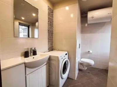 a bathroom with a washing machine and a sink at Cozy 1BR Mountain View Suite for 4 Guests in Bansko