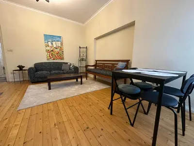 a living room with a table and chairs and a couch at Romantic 1BDR apt near Eagle bridge - Fast Wi-Fi in Sofia