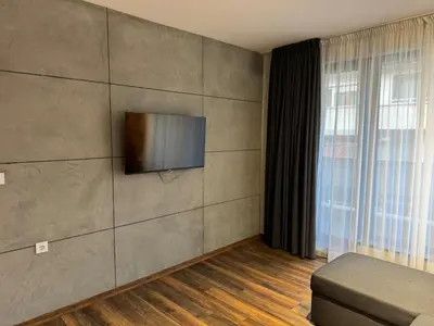 a living room with a flat screen tv on a wall at MedHill Stay - Medical University Area in Plovdiv