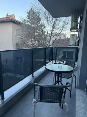 a balcony with a table and chairs on a balcony at MedHill Stay - Medical University Area in Plovdiv