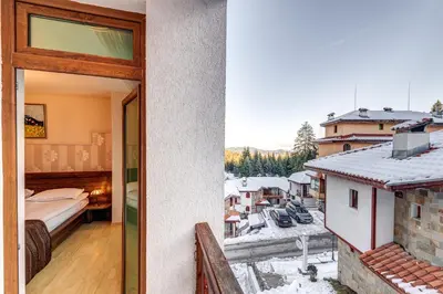 a room with a bed and a view of a city at Апартамент Orpheus Forest in Pamporovo