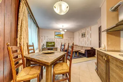 a kitchen and dining room with a wooden table and chairs at Апартамент Orpheus Forest in Pamporovo