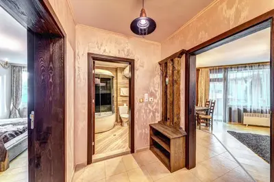 a bedroom with a door leading to a room with a bed at Апартамент Orpheus Forest in Pamporovo